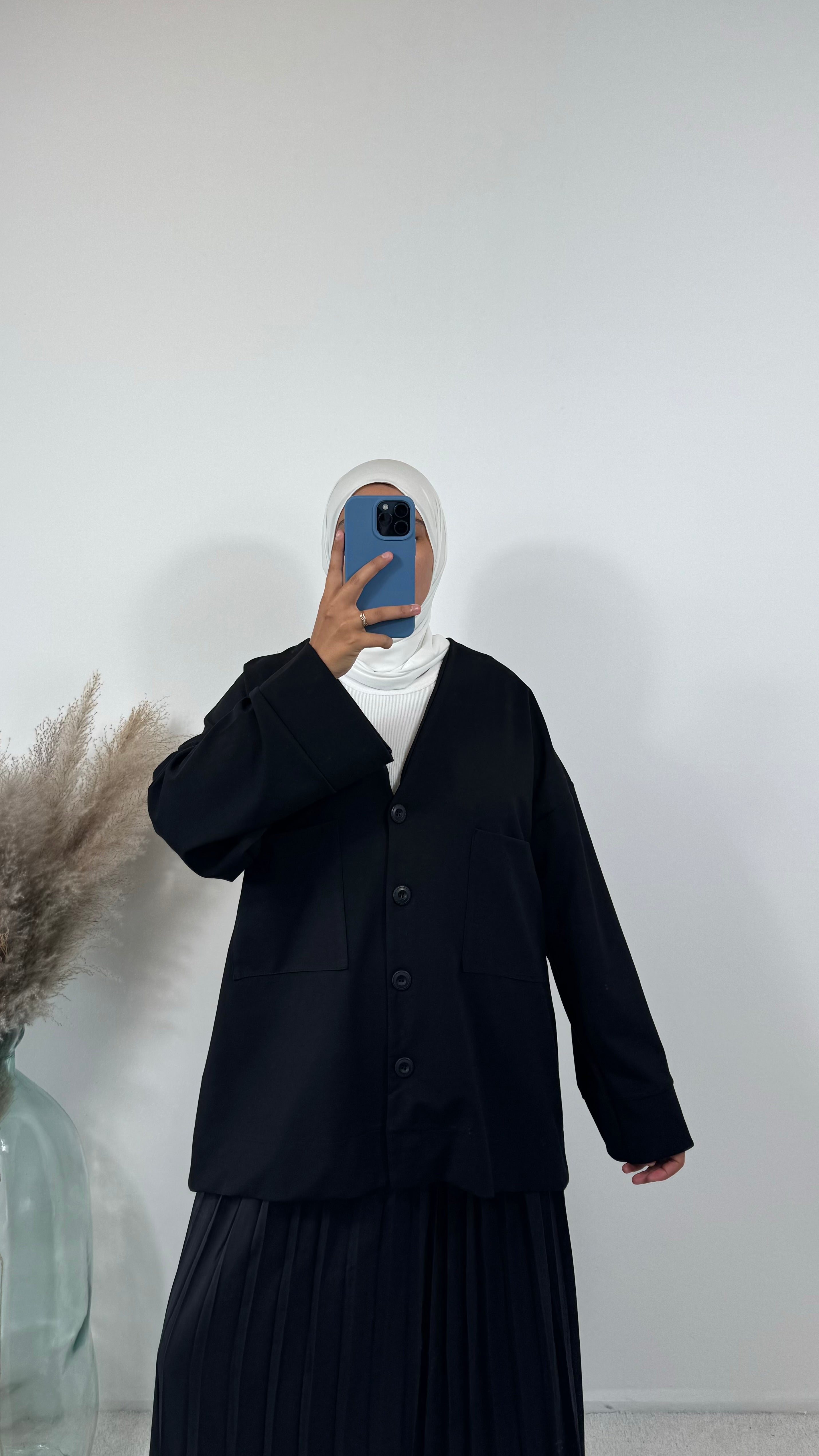 Jupe plissée noire avec des chaussures plates, pour un look décontracté.