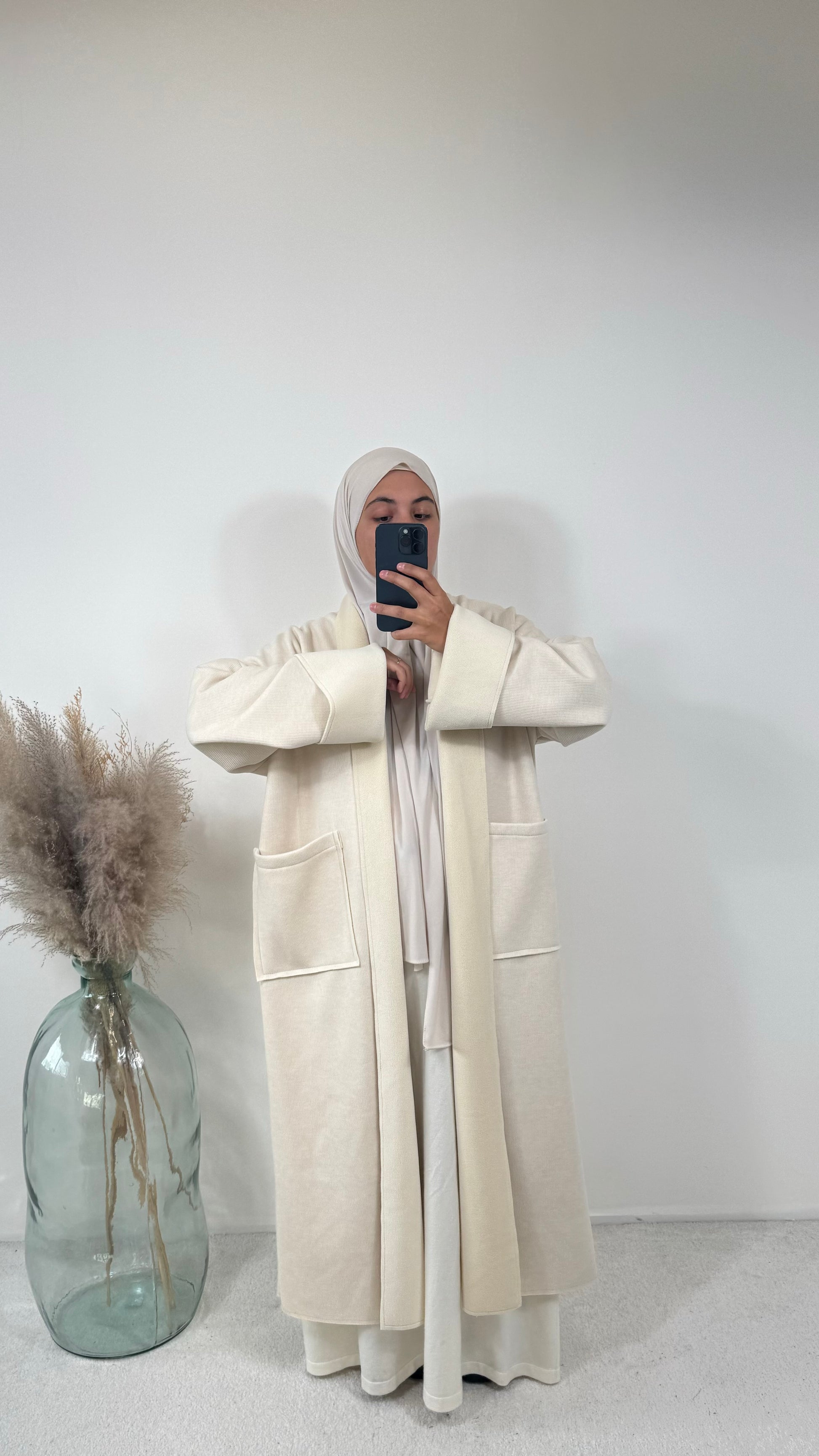 Manteau crème long en coton côtelé avec grandes poches, conçu pour le confort et le style.