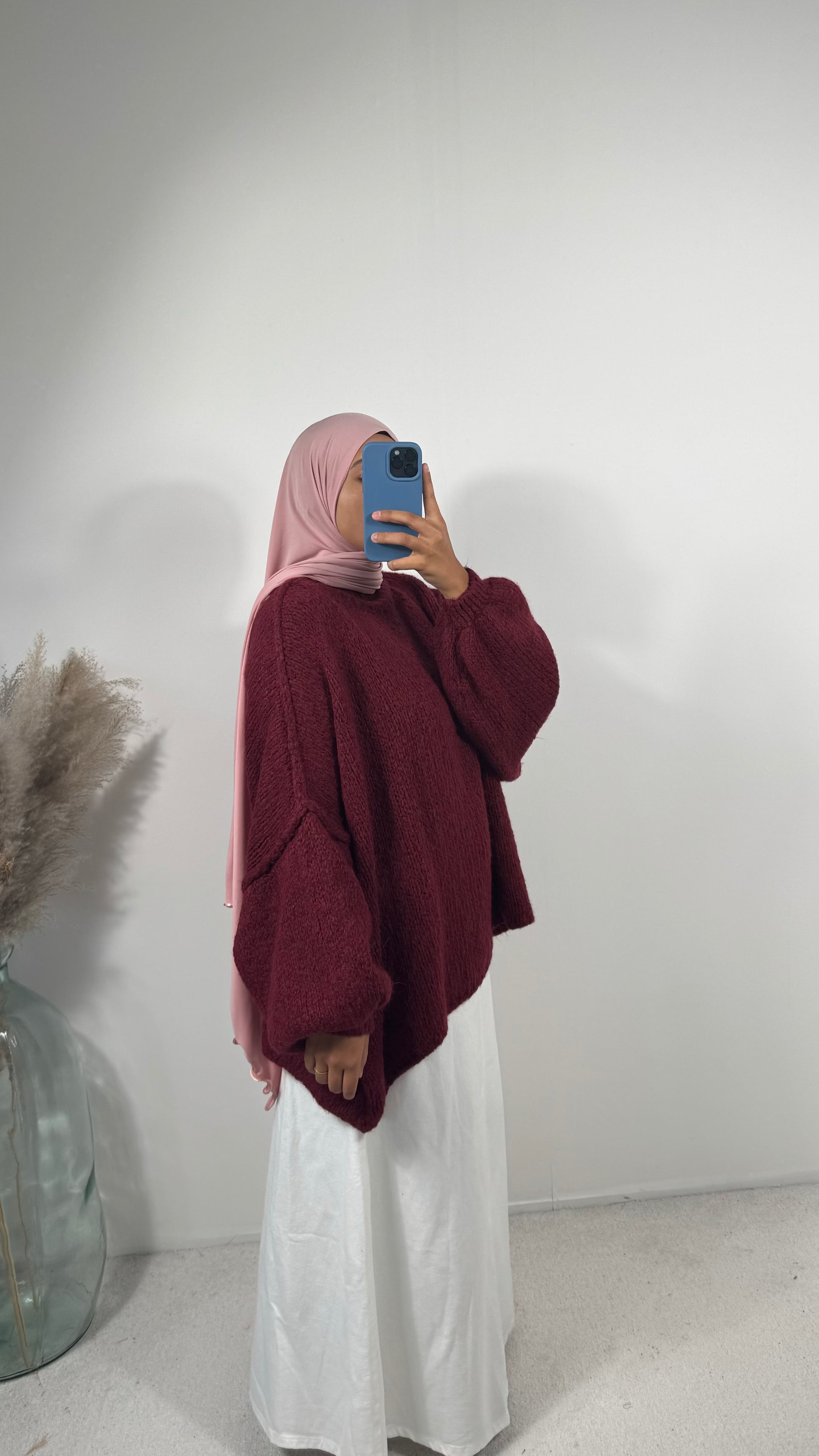 Détail de la texture en laine douce et épaisse du pull oversize bordeaux.