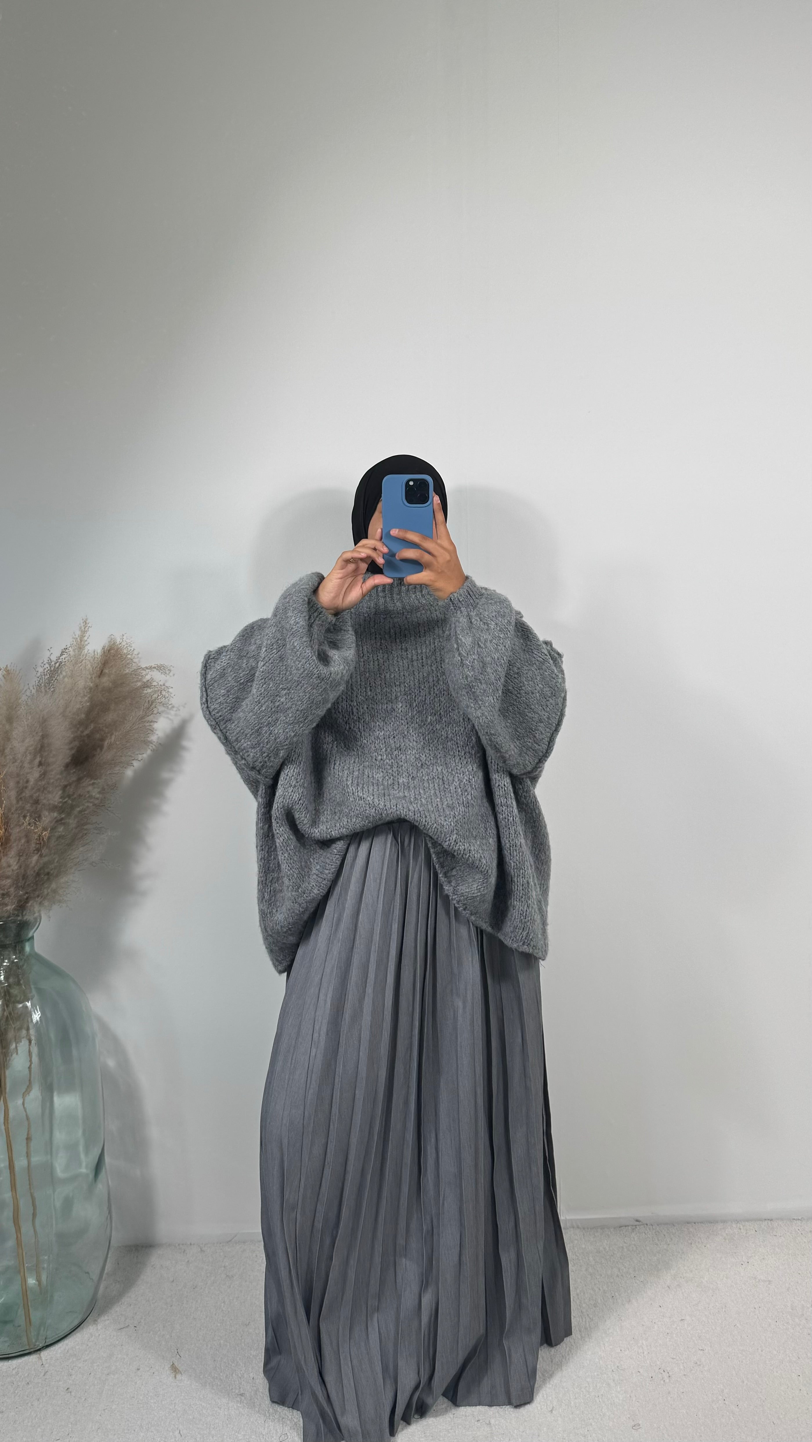 Vue de face de la jupe plissée noire, longue, idéale pour un look élégant et modeste.
