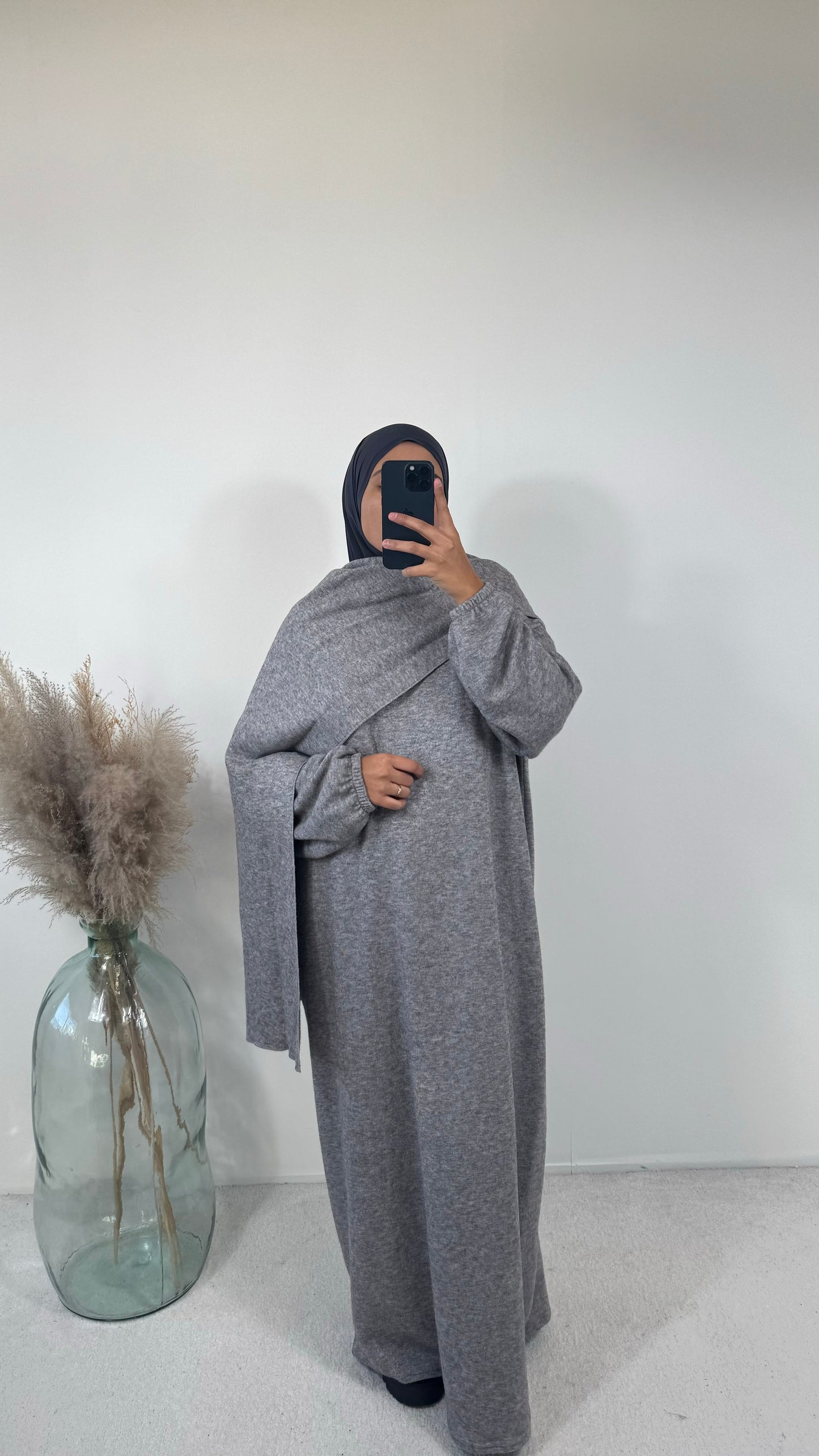 Robe en maille oversize grise avec un drapé élégant pour un look modeste.