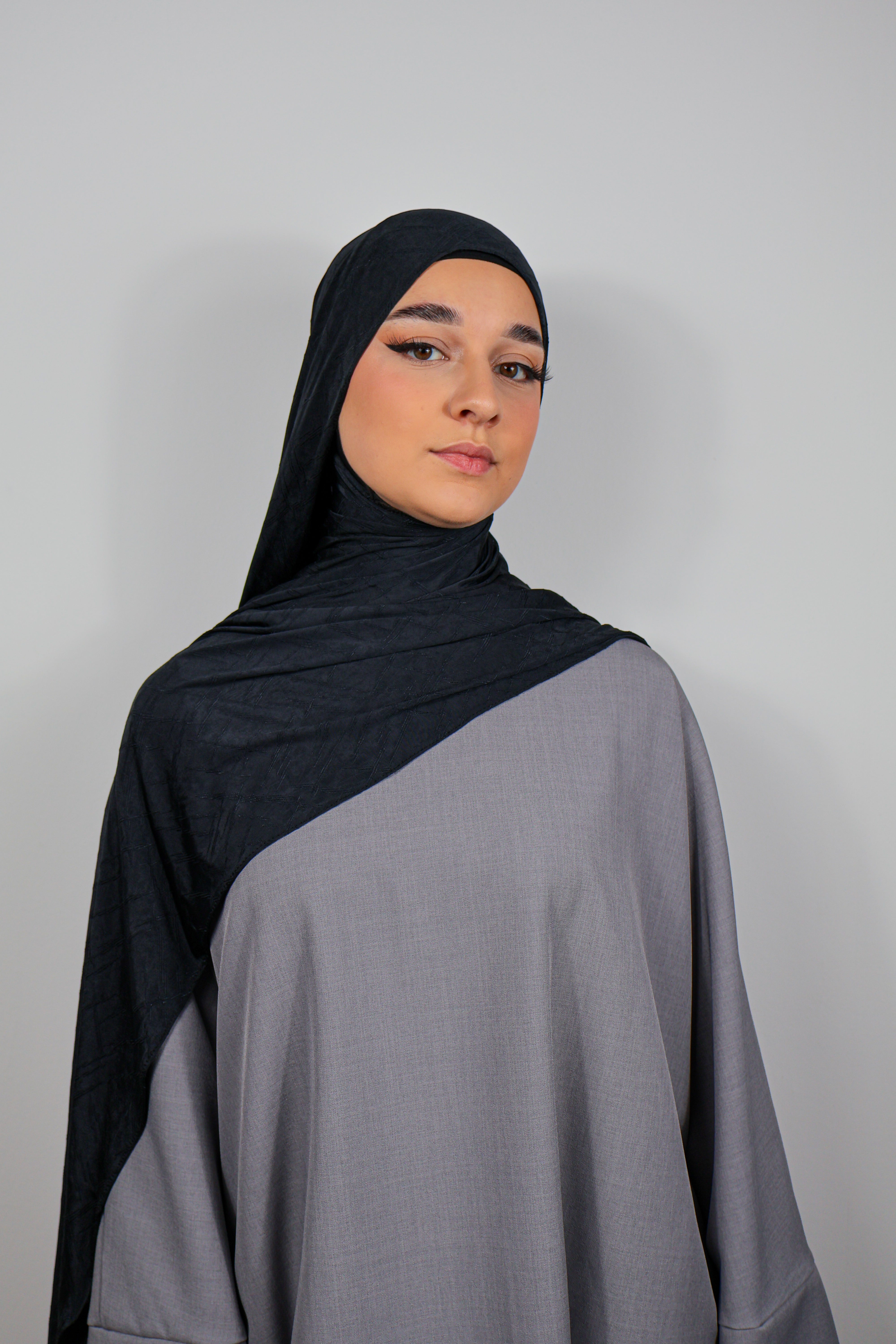 Hijab en Jersey Prestige rose poudré, avec des textures brodées, porté de façon fluide.