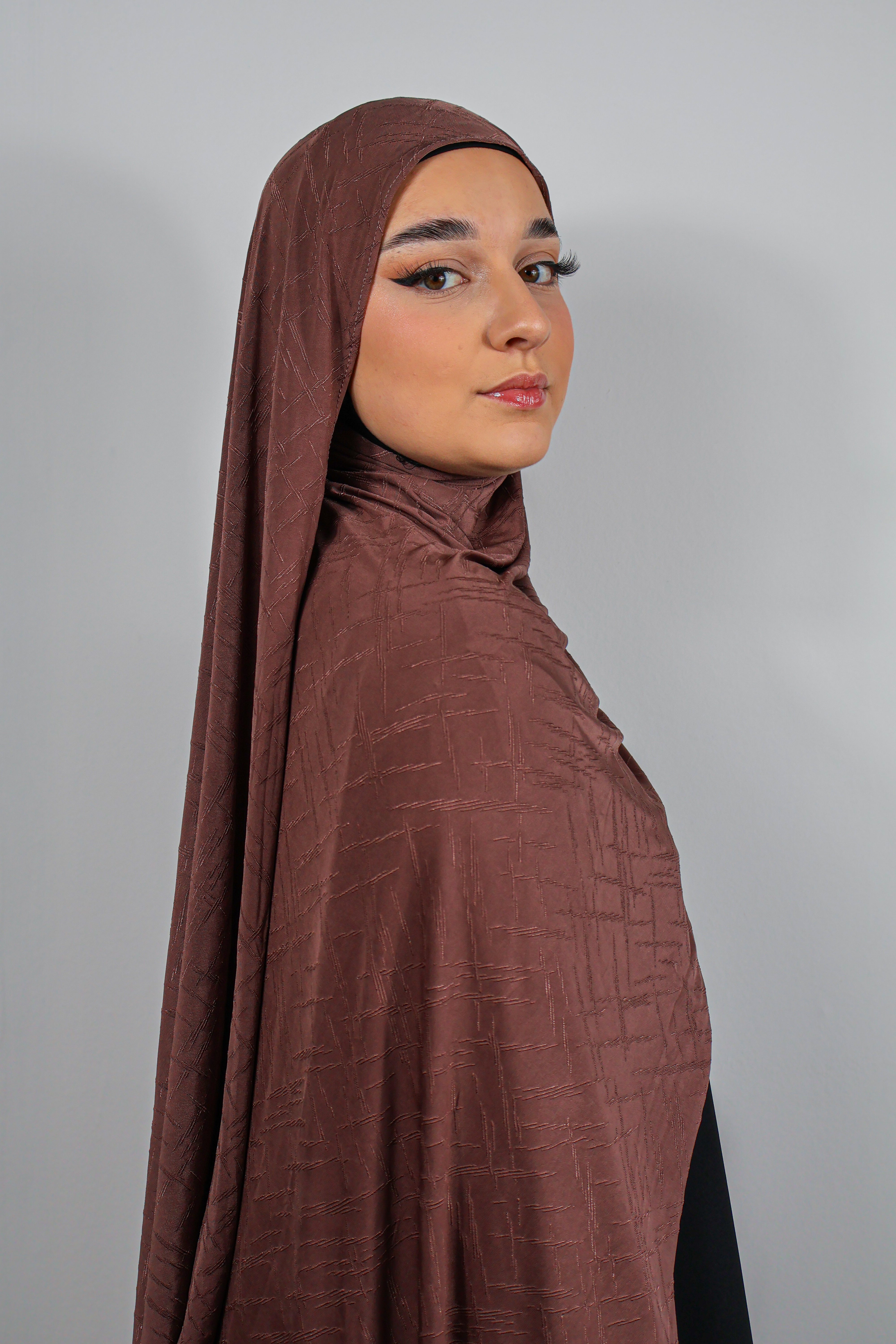 Gros plan sur les textures brodées du Jersey Prestige noir, mettant en valeur les détails du tissu.